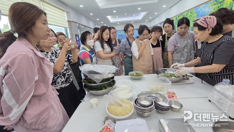 <em>김치 담그기 교육에 참여한 완주군민들이 함께 전통 방식으로 김치를 버무리고 있다.</em>