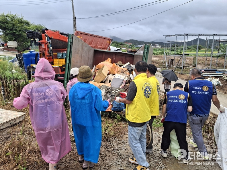 쏟아지는 비 속에서도 자원봉사자들이 어르신의 주거 공간을 정리하고 있다. (사진=부안군 제공)