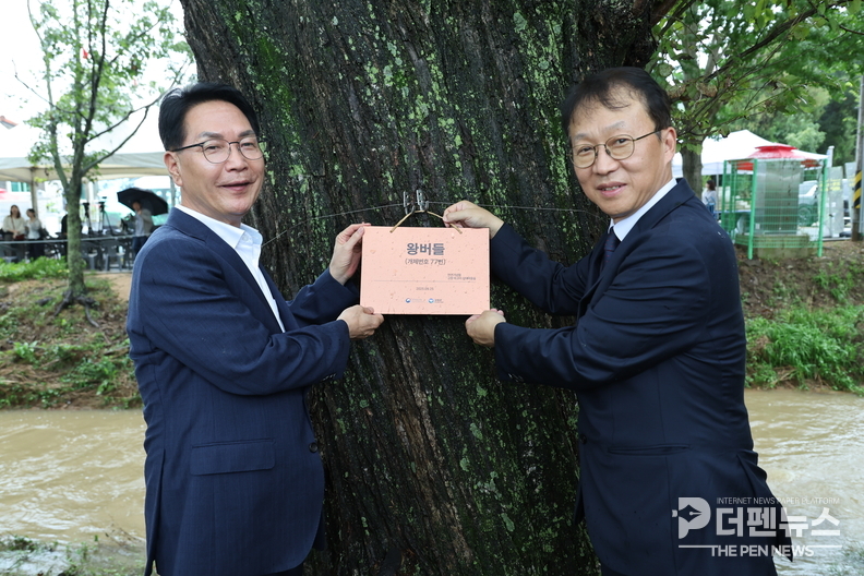 ‘고창 하고리 삼태마을숲, 천연기념물 지정 기념식에서 주민들과 관계자들이 노거수 이름표 달기 퍼포먼스를 진행하고 있다.’