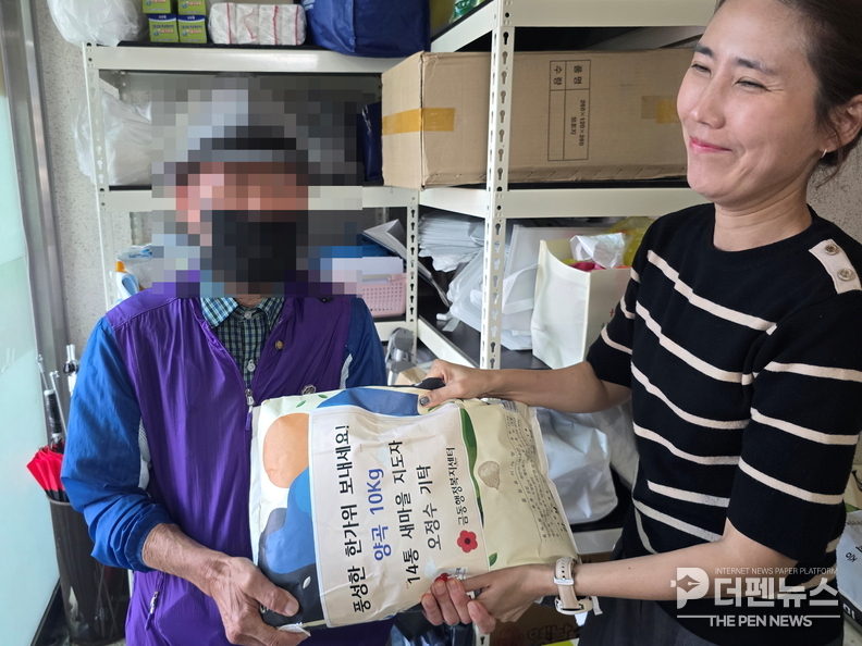 “금동 14통 새마을지도자 오정수 씨가 준비한 백미를 한부모가정에 전달하는 모습.”