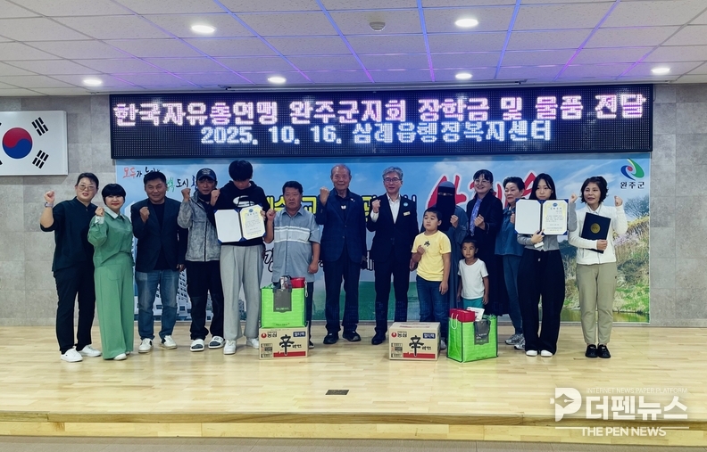 한국자유총연맹 완주군지회 류건옥 회장과 임원들이 삼례읍 우수 학생들에게 장학금과 생필품 꾸러미를 전달하고 기념촬영을 하고 있다.