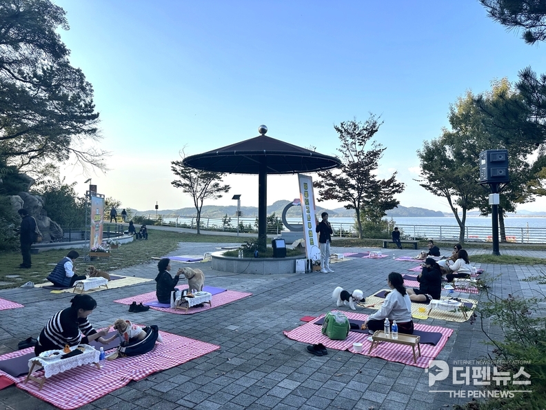 <em>익산시 웅포캠핑장에서 열린 ‘멍룡 도가’ 체험 프로그램에서 참가자들이 반려견과 함께 요가를 즐기고 있다. =익산시 제공</em>